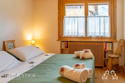 a bedroom with two beds and a window at Dimora del Corso Cortina in Cortina dʼAmpezzo