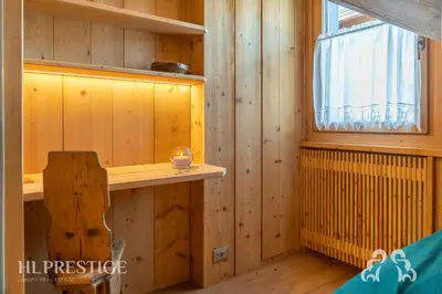 a wooden room with a window and a candle on a shelf at Dimora del Corso Cortina in Cortina dʼAmpezzo