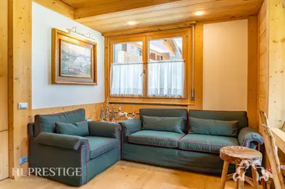 a living room with two blue couches and a window at Dimora del Corso Cortina in Cortina dʼAmpezzo
