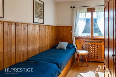 a bedroom with a bed and a dresser and a television at Chalet Boite - Cortina in Cortina dʼAmpezzo
