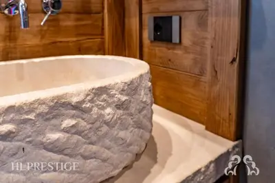 a bathroom with a large stone sink in a room at Alpenglow Cortina Luxury in Cortina dʼAmpezzo