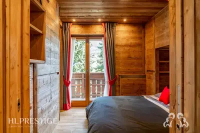 a bedroom with a bed and a window in it at Alpenglow Cortina Luxury in Cortina dʼAmpezzo