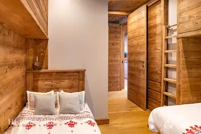 a bedroom with a bed and wooden walls at Alpenglow Cortina Luxury in Cortina dʼAmpezzo