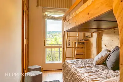 a bedroom with a bunk bed and a window at Olimpic Cà di Bosco in Cortina dʼAmpezzo