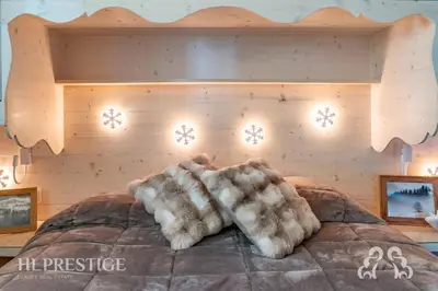 a bed with fur covered pillows on top of it at Olimpic Cà di Bosco in Cortina dʼAmpezzo