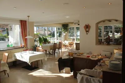 a restaurant with tables and chairs with umbrellas at Hotel Annabell in Merano