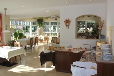 a patio with tables and chairs and umbrellas at Hotel Annabell in Merano