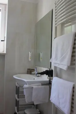 a bathroom with a sink and a toilet and a window at Hotel Annabell in Merano