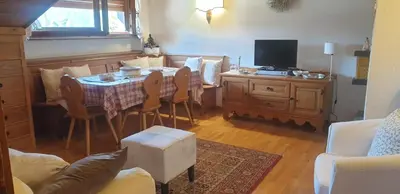 a living room with a table and a tv at Apartment 5 Torri, parcheggio in garage in Cortina dʼAmpezzo