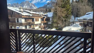 a balcony with a view of snow covered mountains at Apartment 5 Torri, parcheggio in garage in Cortina dʼAmpezzo