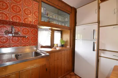 a kitchen with a sink and a refrigerator at Casa Alpina centrale con vista sulle Dolomiti in Cortina dʼAmpezzo