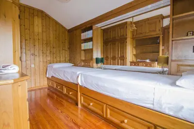 a large bed in a room with wooden walls at Casa Alpina centrale con vista sulle Dolomiti in Cortina dʼAmpezzo