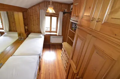 a room with two beds and a window at Casa Alpina centrale con vista sulle Dolomiti in Cortina dʼAmpezzo