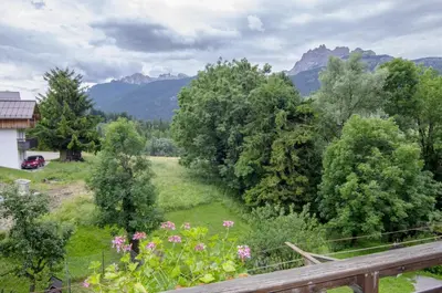 a view of a garden with mountains in the background at Casa Alpina centrale con vista sulle Dolomiti in Cortina dʼAmpezzo