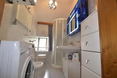 a bathroom with a washing machine and a sink at Casa Alpina centrale con vista sulle Dolomiti in Cortina dʼAmpezzo