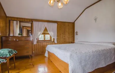 a bedroom with a bed and a dresser and a window at Casa Alpina centrale con vista sulle Dolomiti in Cortina dʼAmpezzo