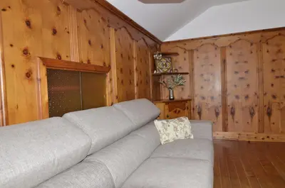 a couch in a living room with wooden walls at Casa Alpina centrale con vista sulle Dolomiti in Cortina dʼAmpezzo