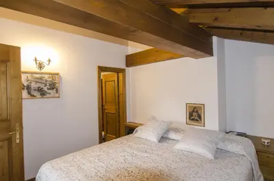 a bedroom with a bed and a wooden ceiling at Comfort a due passi dal centro in Cortina dʼAmpezzo