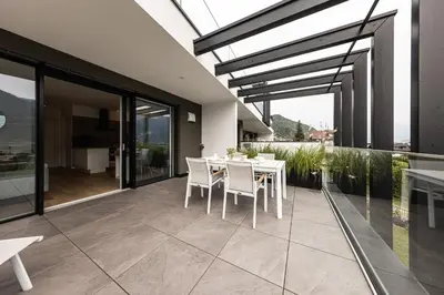 a dining room with a table and chairs on a balcony at Panorama Apartment in Nalles
