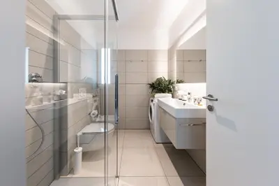 a white bathroom with a sink and a toilet at Panorama Apartment in Nalles