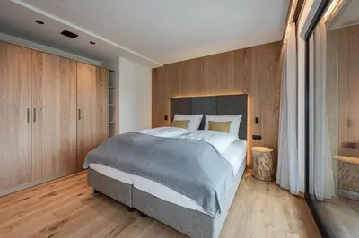 a hotel room with a bed and a window at Knöspele - Brennerei & Genuss-Apartments in Brixen