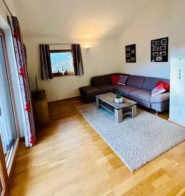a living room with a couch and a table at Frunhaus - Zimmer, Apartments, Ferienwohnungen in Fiumes