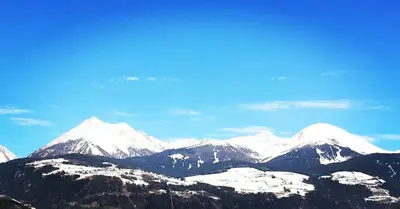 a mountain range with snow capped mountains in the background at Frunhaus - Zimmer, Apartments, Ferienwohnungen in Fiumes