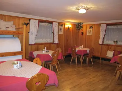 a room with two tables and two bunk beds at Frunhaus - Zimmer, Apartments, Ferienwohnungen in Fiumes