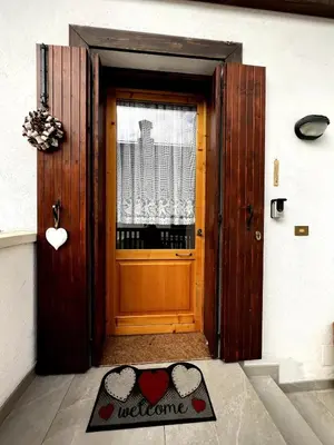 a door with a welcome mat in front of it at La Tana di Giò in Forno di Zoldo