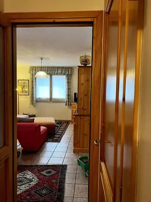 a room with a door open to a living room at La Tana di Giò in Forno di Zoldo