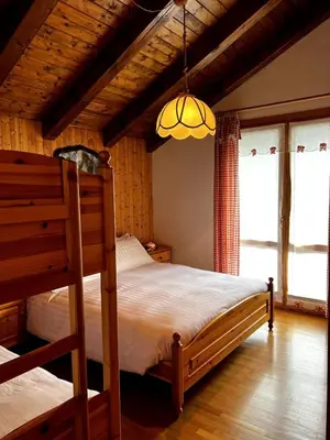 a bedroom with a bunk bed and a chandelier at La Tana di Giò in Forno di Zoldo