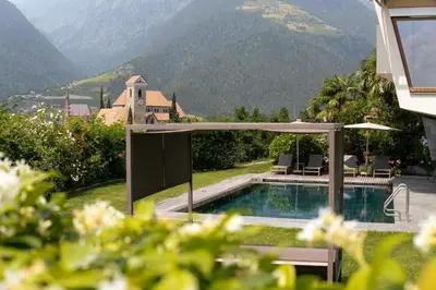 a house with a swimming pool and a patio with a view at Apartment Prairerhof in Schenna
