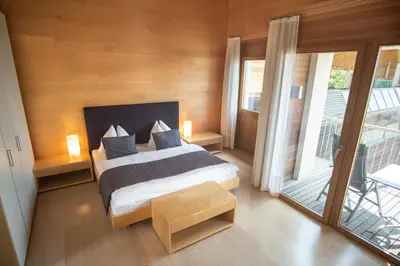 a bedroom with a large bed and a balcony at Apartment Prairerhof in Schenna