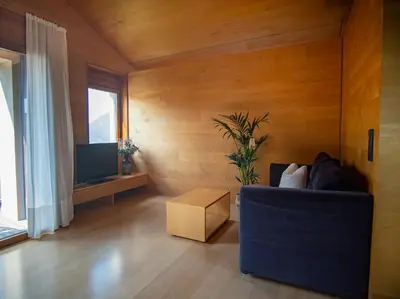 a living room with a blue couch and a tv at Apartment Prairerhof in Schenna