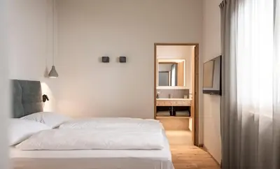 a bedroom with two white beds and a mirror at Florerhof in Schenna