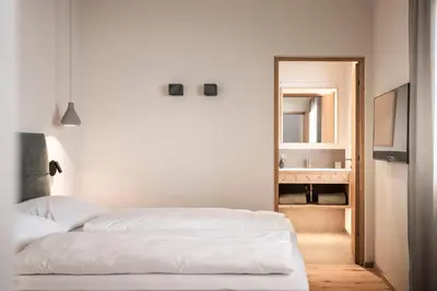 a bedroom with a white bed and a mirror at Florerhof in Schenna