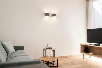 a living room with a couch and a tv at Florerhof in Schenna