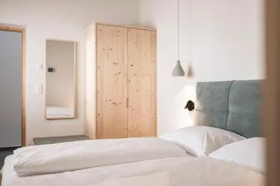 a bedroom with a bed and a wooden cabinet at Florerhof in Schenna