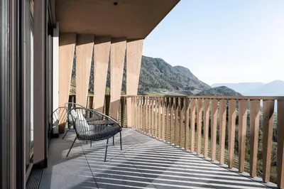 a balcony with two chairs and a view of mountains at Florerhof in Schenna