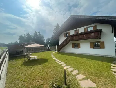 a house with a grass yard next to a building at Apartment Solia in San Genesio Atesino