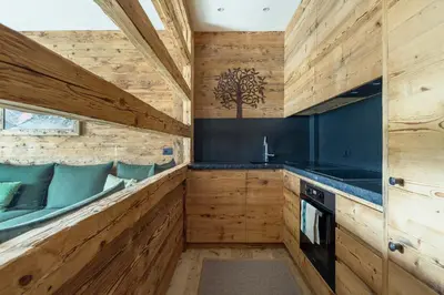 a kitchen with wooden walls and a counter with a sink at Rifugio Tofane - Dolomiti Skyline in Cortina dʼAmpezzo