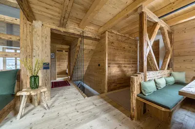 a log cabin with a green couch in a room at Rifugio Tofane - Dolomiti Skyline in Cortina dʼAmpezzo