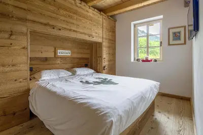 a bedroom with a large bed in a wooden wall at Rifugio Tofane - Dolomiti Skyline in Cortina dʼAmpezzo