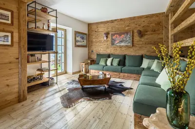a living room with a green couch and a table at Rifugio Tofane - Dolomiti Skyline in Cortina dʼAmpezzo
