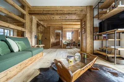 a living room with a green couch and a table at Rifugio Tofane - Dolomiti Skyline in Cortina dʼAmpezzo