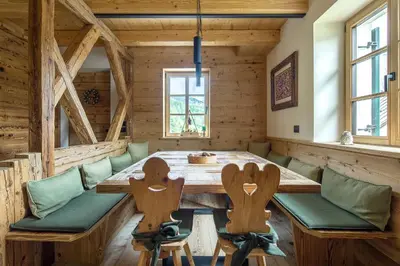 a dining room with a wooden table and chairs at Rifugio Tofane - Dolomiti Skyline in Cortina dʼAmpezzo