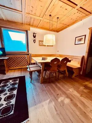 a dining room with a table and a tv at Apartament Loft Fiemme in Castello di Fiemme