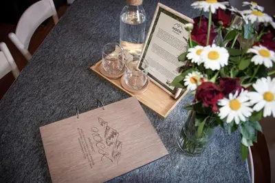a table with a card and a vase of flowers at Nock Apartment Dolomites in South Tyrol - Italy in Nova Ponente