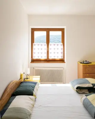 a bedroom with two beds and a window at El Casel dei Masi in Grumes