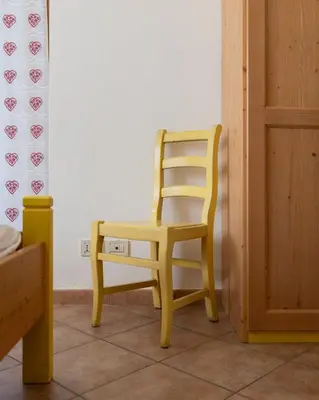 a yellow chair sitting in a room at El Casel dei Masi in Grumes